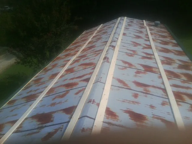 Rusted metal roof panels with new wood purlins before replacement — Storm Damage Roof Repair in Bluemont by Roofing Brothers