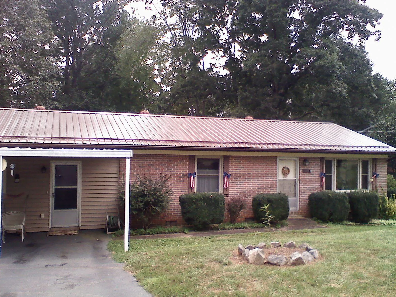 Bronze metal roof and carport on a brick ranch home — Roof Repair work by our crew in Bluemont